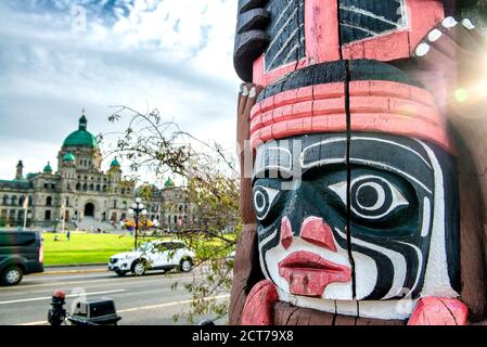 ÎLE DE VANCOUVER, CANADA - le 14 AOÛT 2017 : totem le long du port de Victoria avec des édifices médiévaux en arrière-plan. Banque D'Images