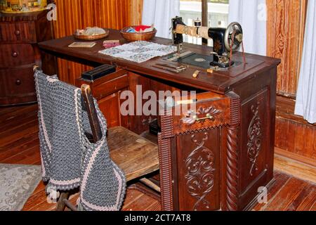 Machine à coudre antique, armoire en bois ornée, instruments, pièce matelassée, chandail, Guptill House, Historic Spanish point, Floride, Osprey, FL Banque D'Images