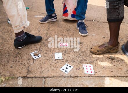 Jouer un jeu de cartes sur le trottoir ou la rue avec des jambes de hommes visibles dans Pilgrims Rest, le concept de l'Afrique du Sud vie quotidienne en Afrique Banque D'Images