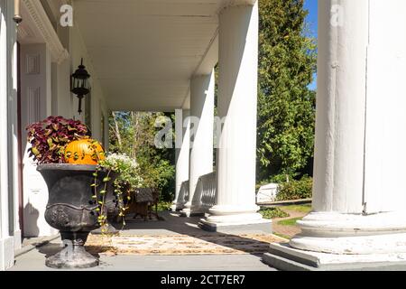 Porche en façade de manoir avec colonnes et urnes décoratives en automne Banque D'Images