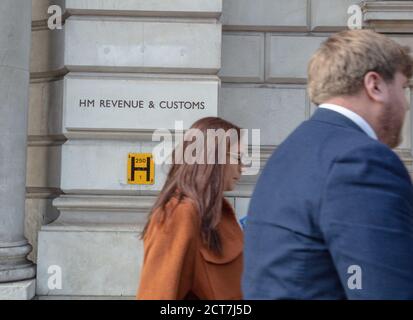 Deux personnes ont vu passer le bâtiment et le bureau HM Revenue & Customs du gouvernement britannique, situé au 100 Parliament Square, à Londres. Banque D'Images