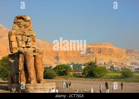 Egypte - 2013, Colossi de Memnon en Egypte avec les montagnes en arrière-plan et les touristes appréciant la vue Banque D'Images