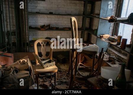 Une ancienne chambre dans un bâtiment abandonné avec deux chaises Plein de débris et de déchets Banque D'Images