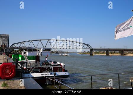 Nimègue, pays-Bas - septembre 18. 2020: Vue de la promenade de la rivière au-delà de conteneur et bateau de croisière sur la rivière waal avec pont arrière de snelbinder Banque D'Images