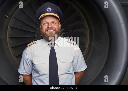 Pilote contenté posé devant la pièce du plan Banque D'Images