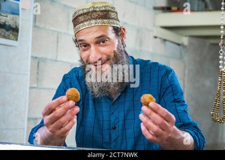 Ancien vendeur musulman authentique dans le marché de la vieille ville situé entre le quartier juif et le quartier musulman. Offre un falafel gratuit. Boutiques de souvenirs à Banque D'Images