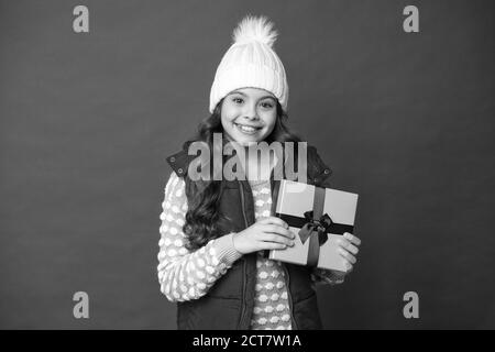 Vrai bonheur. Faites des choses agréables. Joyeux enfant en hiver fond rouge. Nouvelle année à venir. Petit coffret cadeau pour enfant. Bonne enfance. Cadeaux de Noël souvenirs. Préparez-vous pour les vacances d'hiver. Banque D'Images