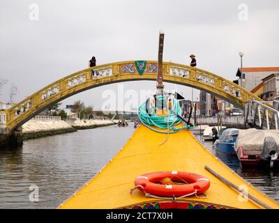 Bateau touristique traditionnel Moliceiro passant par le pont de Carcavelos sur le canal de Sao Roque, Aveiro, Portugal Banque D'Images