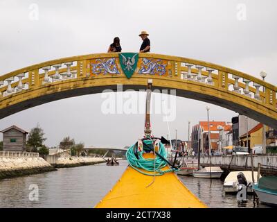 Bateau touristique traditionnel Moliceiro passant par le pont de Carcavelos sur le canal de Sao Roque, Aveiro, Portugal Banque D'Images