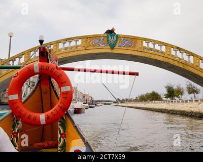 Bateau touristique traditionnel Moliceiro passant par le pont de Carcavelos sur le canal de Sao Roque, Aveiro, Portugal Banque D'Images