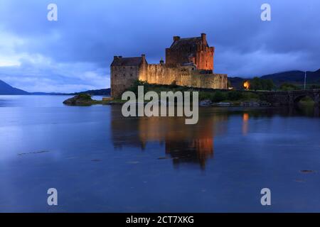 Eileen Donan Castle a illuminé après le coucher du soleil, dans une soirée nuageux, West Highlands, Écosse, Royaume-Uni Banque D'Images