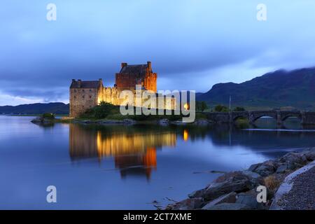 Eileen Donan Castle a illuminé après le coucher du soleil, dans une soirée nuageux, West Highlands, Écosse, Royaume-Uni Banque D'Images