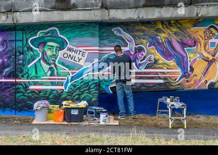 L'artiste Anthony Joseph peignant Hogan's Alley, la fresque de l'histoire des Noirs sur Dunsmuir Viaduct, Vancouver (Colombie-Britannique), Canada Banque D'Images