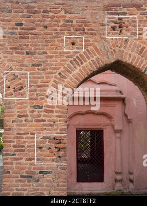 des marques de balles sur un mur entourent une arche au site du massacre de bagh de jallianwala à amritsar, en inde Banque D'Images