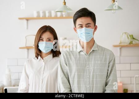 portrait d'un jeune couple asiatique portant un masque regardant appareil photo Banque D'Images