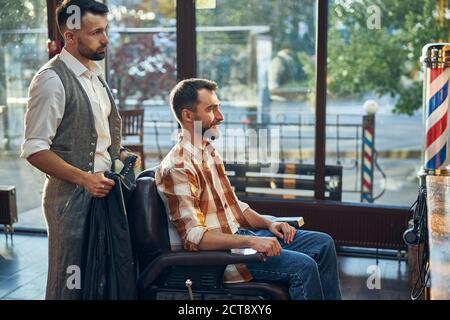 coiffeur qualifié et son client regardant dans le miroir Banque D'Images