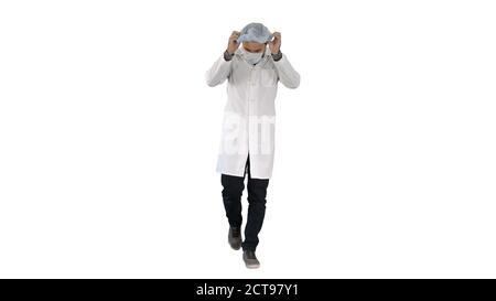 Marcher beau médecin portant un masque et un chapeau sur fond blanc Banque D'Images