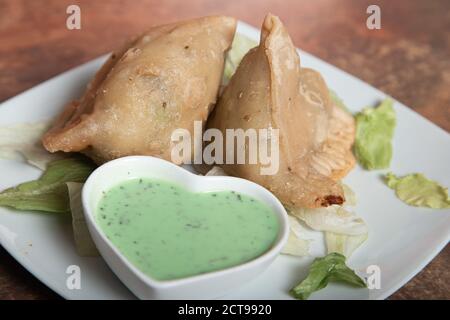 Cuisine traditionnelle indienne ou pakistanaise du Ramadan, Samosa à la sauce verte, nourriture à l'iftar de Ramzan, cuisine de rue épicée, collations célèbres dans le pays asiatique. Banque D'Images