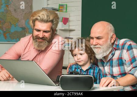 Homme dans différents regardant l'écran d'ordinateur portable, le réseau social. Le père et le fils de l'ancien grand-père utilisent un ordinateur portable. Famille Multi-génération masculine avec Internet Banque D'Images