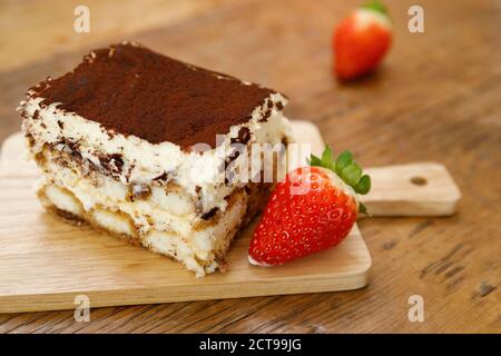 Tiramisu. Dessert italien traditionnel sur une assiette en bois. Banque D'Images