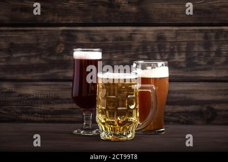 Différentes sortes de bière pression en verres et mug sur table en bois, espace de copie. Bière fraîche brassée. Banque D'Images