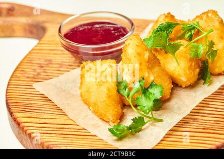 Nuggets de fromage frits avec sauce aux baies sur bois carte Banque D'Images