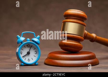 Réveil et marteau jugez le gavel sur fond marron Banque D'Images