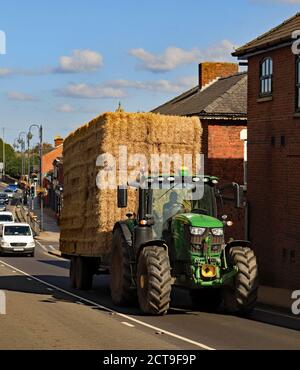 Au début de l'automne à Burscough, un tracteur et une remorque font son chemin jusqu'au pont au-dessus du canal avec une charge de paille étant prise pour le stockage dans une grange. Banque D'Images