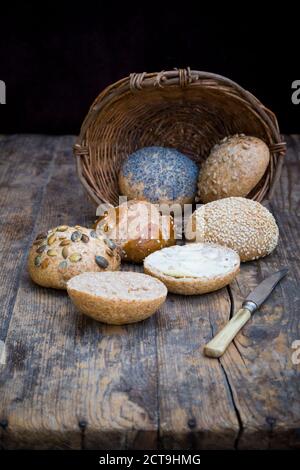 Ensemble de petits pains différents repas, panier à pain, couteau et le beurre Banque D'Images