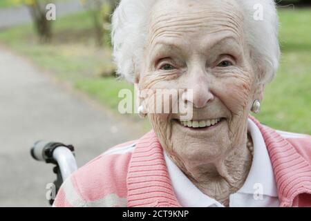 Allemagne, North Rhine Westphalia, Cologne, Portrait of senior woman sitting sur fauteuil roulant, smiling Banque D'Images