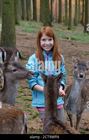 Germany, Bavaria, Munich, fille et son père à l'alimentation des chevreuils Wildlife park Banque D'Images