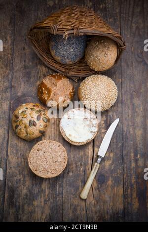 Ensemble de petits pains différents repas, panier à pain, couteau et le beurre Banque D'Images