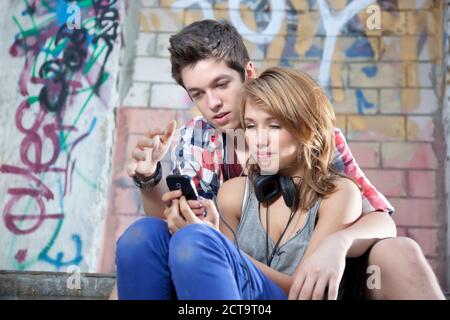 Allemagne, Berlin, Young couple on mobile phone Banque D'Images