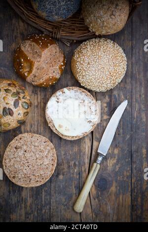 Ensemble de petits pains différents repas, panier à pain, couteau et le beurre Banque D'Images