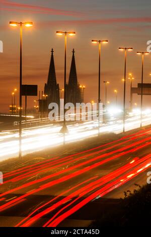 L'Allemagne, en Rhénanie du Nord-Westphalie, la cathédrale de Cologne et de la circulation routière sur les courts de Zoobruecke au crépuscule Banque D'Images