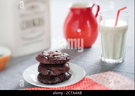 Les cookies au chocolat avec des cerises séchées et verre de lait Banque D'Images