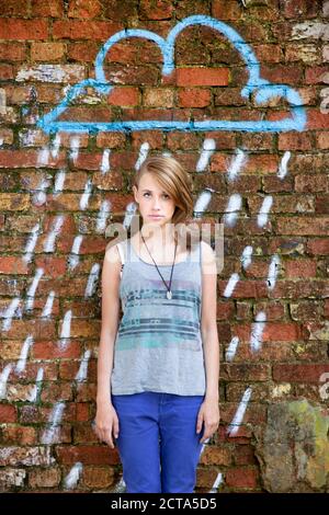 Allemagne, Berlin, Portrait of teenage Girl standing in front of wall avec graffiti Banque D'Images