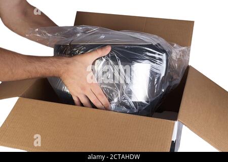 Emballage des marchandises dans une boîte en carton avec du matériau en mousse de polystyrène pour le transport sécuritaire des marchandises. Isolé sur fond blanc. Les mains de l'homme sont l'emballage de la goo Banque D'Images