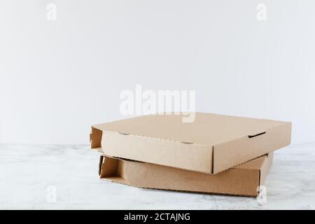 Boîtes à pizza en carton sur table sur fond blanc avec espace de copie. Service de livraison de pizzas. Banque D'Images