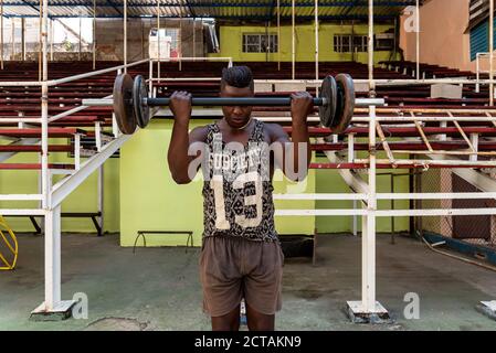 4 septembre 2019 : poids de levage de boxeur dans une salle de gym. La Havane, Cuba Banque D'Images