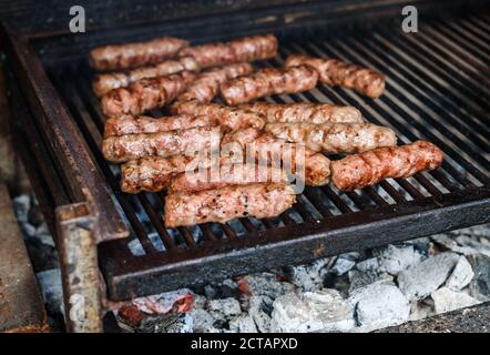 Griller de la viande sur un barbecue au charbon chaud. Préparation, cuisson de cafevcici, kebabs, saucisse de campagne sur barbecue au charbon de bois dans la cheminée extérieure. Tr Banque D'Images