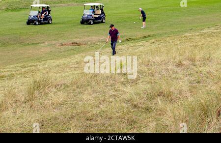 Golfeur à la recherche d'une balle dans l'épais rugueux sur le deuxième trou de Littlehampton Golf Club, un vrai parcours de liens dans West Sussex; fondé en 1889. Banque D'Images