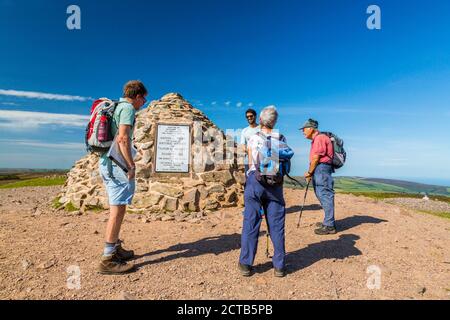 Marcheurs au sommet commémoratif cairn sur Dunkery Beacon, le point culminant du Somerset et du parc national d'Exmoor (1 705 pieds), Angleterre, Royaume-Uni Banque D'Images