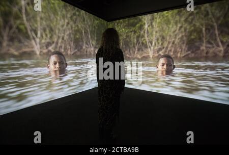 Une personne regarde un film numérique à trois canaux appelé 'Narrenschiff' par l'artiste Kehinde Wiley lors d'un aperçu de la presse au musée Box de Plymouth, qui inclut la plus grande exposition commémorative du Royaume-Uni sur le Mayflower avec des œuvres prêtées par les instituts Smithsonian et Peabody en Amérique. Banque D'Images