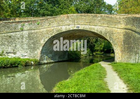 Pont 47 sur le Grand Union Canal vu près de Blisworth dans le Northamptonshire avec des réflexions sous le pont et dans l'eau. Banque D'Images