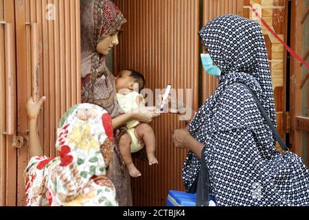 Rawalpindi. 22 septembre 2020. Un travailleur de la santé marque le doigt d'un enfant après avoir administré le vaccin contre la polio lors d'une campagne de vaccination porte-à-porte contre la polio à Rawalpindi, dans la province orientale du Punjab, au Pakistan, le 22 septembre 2020. Un nouveau cycle de campagne nationale contre la polio a débuté lundi dans le but d'atteindre 40 millions d'enfants à travers le pays avec le vaccin contre la polio, selon un communiqué de presse sur le site Internet du Programme d'éradication de la poliomyélite au Pakistan. Crédit : Ahmad Kamal/Xinhua/Alamy Live News Banque D'Images