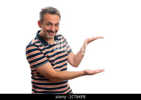 Sympathique homme modèle souriant d'adulte comme présentant vide copyspace pour texte publicitaire dans les mains portant décontracté t-shirt d'été tenue isolée sur bac blanc Banque D'Images