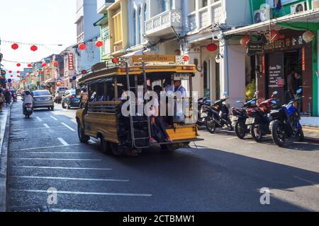 Phuket, Thaïlande - 26 février 2018 : bus public thaïlandais jaune en voiture dans le centre-ville. Véhicule de la ville Songthaew avec passants sur route, attention douce Banque D'Images