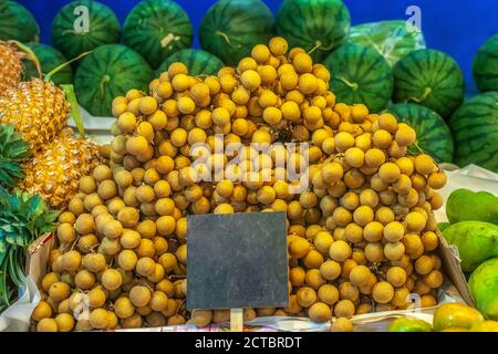 Fruits tropicaux doux Dimocarpus longan petits pains, ananas et pastèques vendus sur le marché des agriculteurs Banque D'Images