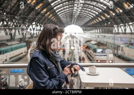 Femme assise dans un restaurant de la gare ferroviaire de Milan, Italie. Banque D'Images